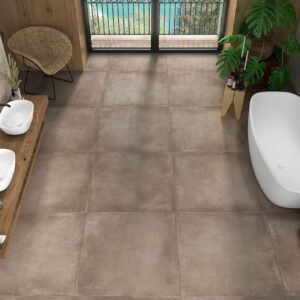 Baño expositor con grandes baldosas marrón grisáceo, bañera exenta y lavabos blancos