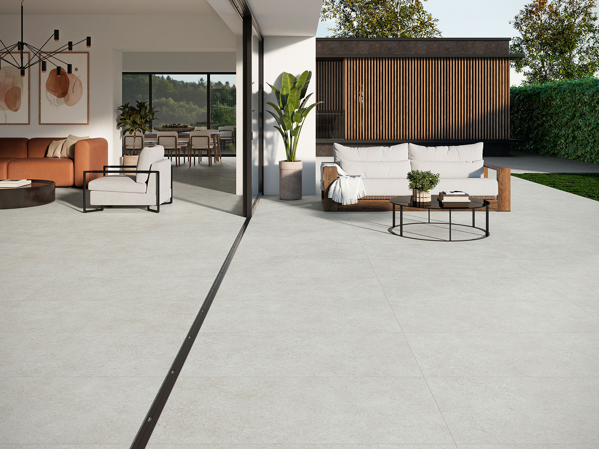 Zona interior-exterior con grandes losas cerámicas claras y muebles de salón.