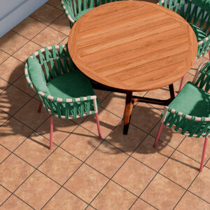 Terraza con pavimento cerámico color teja, mesa redonda de madera y tres sillas verdes