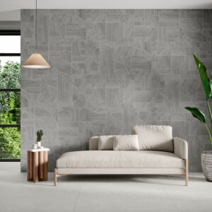 Sala de exposición con pared cerámica gris geométrica, sofá beige y suelo de pavimento cerámico
