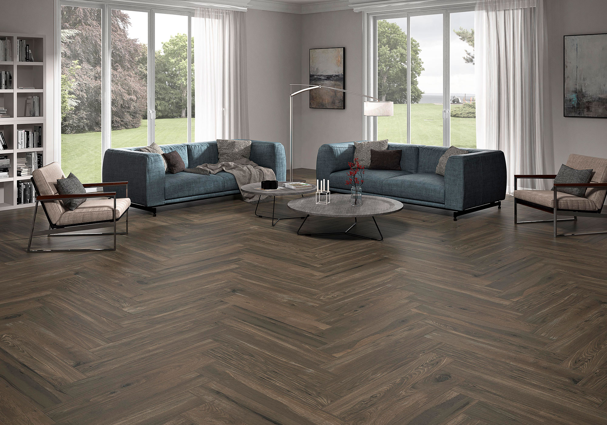 Pavimento cerámico efecto madera en espiga en salón con sofás azul petróleo y ventanales