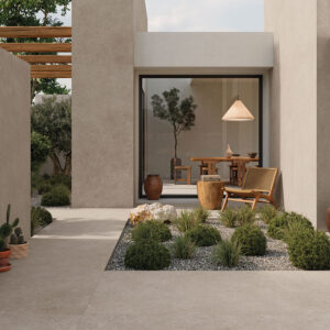AMB_STN_KRETA-GREIGE-120X280 Patio minimalista con pavimento cerámico beige, jardinera de grava y mobiliario de madera