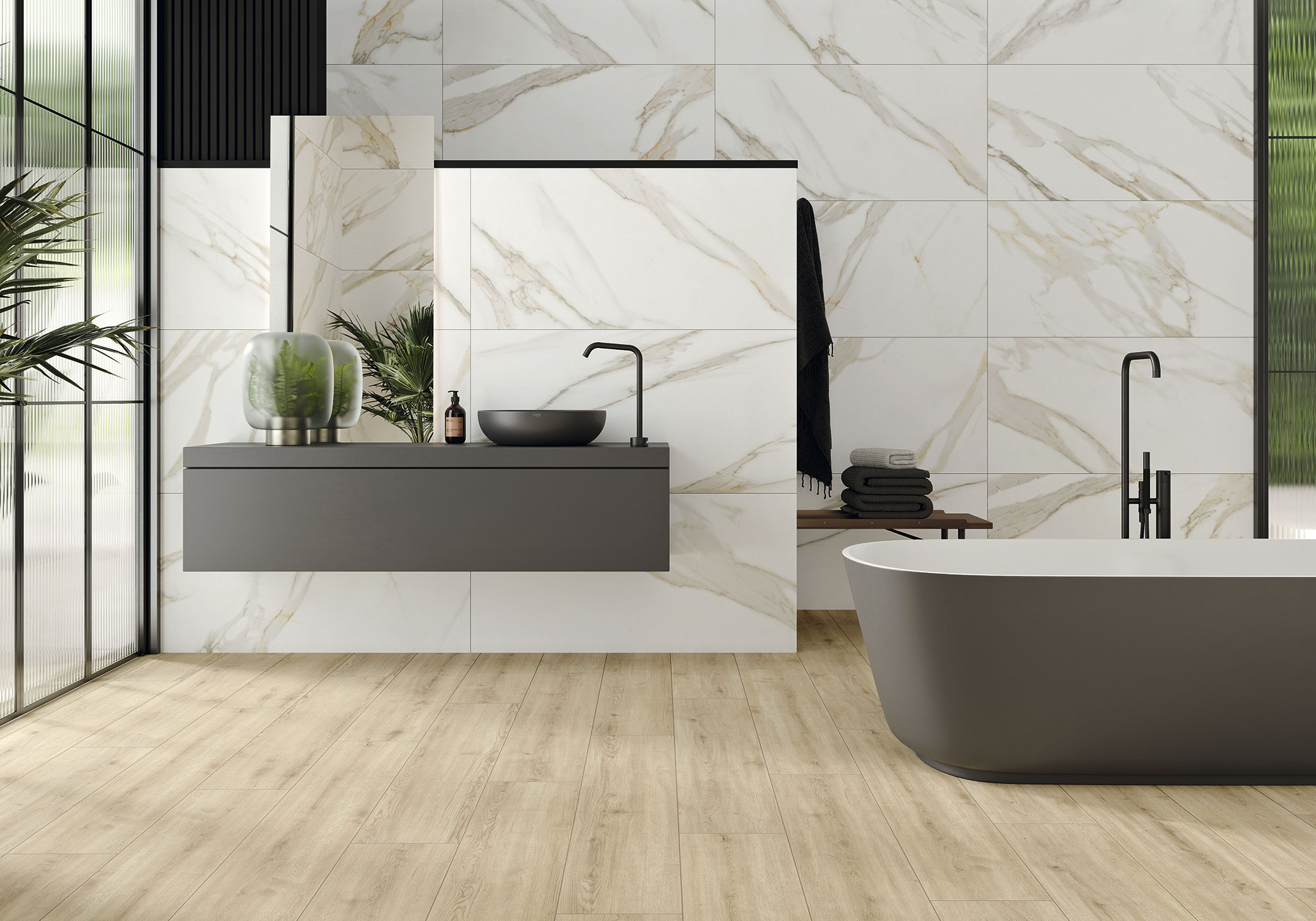 Showroom baño: azulejos efecto mármol, suelo madera, bañera exenta y mueble suspendido