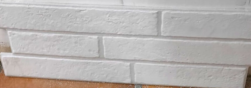 Panel de azulejos cerámicos blancos con textura de ladrillo y juntas visibles