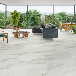 Salón luminoso con pavimento cerámico efecto mármol, sofá, mesa baja y grandes ventanas