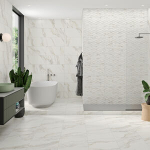 Baño expositivo con azulejos efecto mármol, bañera exenta, ducha y mueble lavabo.