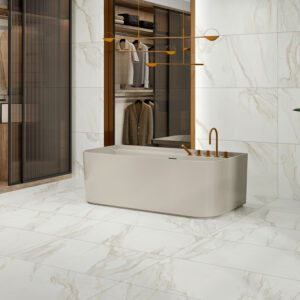 Bañera exenta en tienda con azulejos efecto mármol blanco y grifería dorada