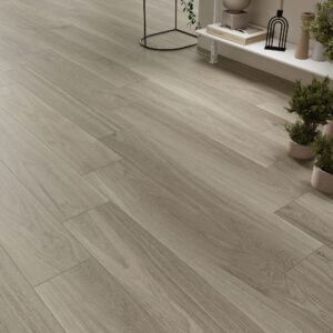 NUK-GREY-23X120 Suelo cerámico efecto madera con lamas claras y estante decorativo en showroom