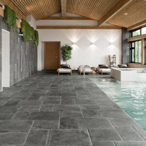 SAINT-ANDREWS-ANTRACITA-MULTIFORMATO-(1) Salón con piscina y pavimento cerámico gris tipo piedra, revestimiento mural y techo madera