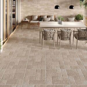 Terraza con pavimento cerámico beige tipo piedra, mesa y sillas de exterior