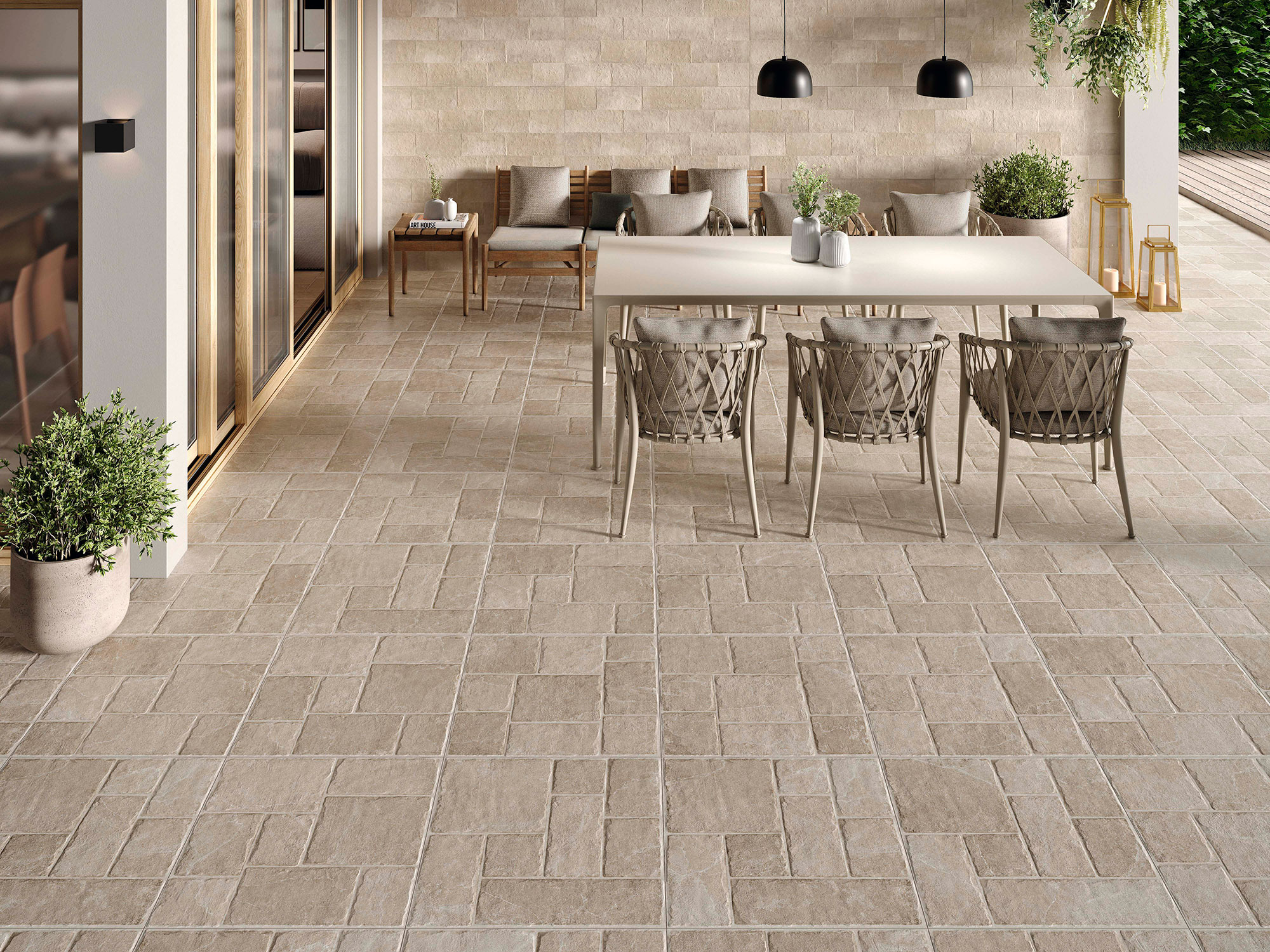 Terraza con pavimento cerámico beige tipo piedra, mesa y sillas de exterior