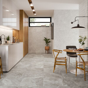 Cocina-comedor moderno con pavimento y revestimiento cerámico gris, muebles de madera y mesa.